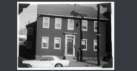 This is an old black and white photo of the original building. It looks to be painted a darker color.