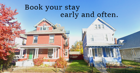 A google street view image of the two Sneer Houses side by side: one, a handsome red brick house built in 1904. The other, a quaint yet tall blue home of narrow siding. Together, they stand upon three lots' of space.

Text on the image says "book your stay early and often."